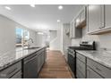 Modern kitchen featuring gray cabinets, granite countertops, stainless steel appliances, and hardwood floors at 807 Pryor St # 45, Mebane, NC 27302