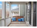 Inviting front porch with a porch swing and decorative pillows, perfect for relaxing outside on this lovely home at 909 Edgewater Cir, Chapel Hill, NC 27516