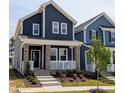 Charming two-story home featuring a welcoming front porch with beautiful landscaping and a modern color scheme at 936 Allen Park Dr, Raleigh, NC 27604