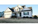 Charming two-story home with a white exterior, black shutters, and an attached two car garage at 100 Vinson Park Dr, Clayton, NC 27527