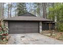 Charming single-story home featuring a stone-accented facade, brown garage door and wooded surroundings at 118 Flora Mcdonald Ln, Cary, NC 27511