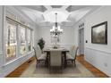 Bright dining room featuring decorative tray ceiling, large windows, chandelier and space for a table for six at 1196 Smith Creek Way, Wake Forest, NC 27587