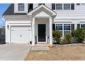 Close-up of the front door and garage of a white two-story house with manicured landscaping at 121 Black Oak Ct, Clayton, NC 27520