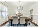 Elegant dining room featuring a modern chandelier, a stylish rug, and seating for six for memorable meals at 131 Tracker Ct, Garner, NC 27529