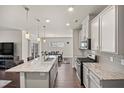 Kitchen with granite island, stainless appliances, and wood floors, open to dining area at 1401 Wrenn Rd, Durham, NC 27703