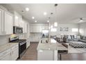 Bright kitchen features granite counters, stainless appliances, and open layout to the living room at 1401 Wrenn Rd, Durham, NC 27703