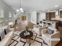Living room with modern furniture, hardwood floors, and an adjacent open kitchen at 1419 Glenwater Dr, Cary, NC 27519
