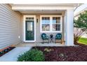 Inviting front porch with cozy seating and a decorative glass front door at 174 Coalyard Dr, Garner, NC 27529