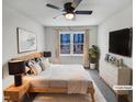 Bright bedroom with a wooden bed frame, ceiling fan, and an outside view at 205 Dwelling Pl, Knightdale, NC 27545