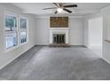Bright living room with a brick fireplace, ceiling fan, and large window at 205 Dwelling Pl, Knightdale, NC 27545
