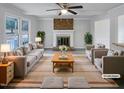 Bright, staged living room features a cozy brick fireplace, ceiling fan, and neutral decor at 205 Dwelling Pl, Knightdale, NC 27545