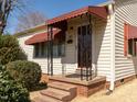 Inviting front entry featuring awnings, decorative ironwork, and a concrete stoop at 2116 Mckinney St, Burlington, NC 27217