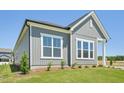 Attractive gray exterior of a new home with neatly landscaped yard, bright windows, and clear blue skies above at 273 Marvel Dr # 139, Rolesville, NC 27571
