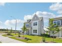 Charming two-story home with gray siding, white trim, and landscaping, complemented by blue skies and clouds at 2880 Quarry Rd # 163, Rolesville, NC 27571