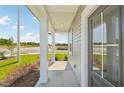 A covered front porch with elegant columns and views of the landscaped yard and neighborhood at 2880 Quarry Rd # 163, Rolesville, NC 27571