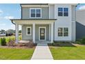 Welcoming front porch with classic columns and manicured landscaping leading to a modern, stylish home at 2880 Quarry Rd # 163, Rolesville, NC 27571