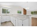 Open kitchen featuring white cabinetry, granite countertops, and an eat-in bar area at 292 Cedar Lake Rd # A, Chapel Hill, NC 27516