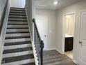 Bright entryway featuring dark wood stairs and flooring, a hall closet and a bathroom at 3009 Honeymyrtle Ln, Durham, NC 27703