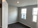 Bedroom with two windows and neutral walls, offers natural light and wood-look flooring at 3011 Honeymyrtle Ln, Durham, NC 27703