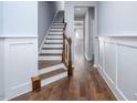 Inviting foyer with hardwood floors, wainscoting, and an elegant staircase at 345 Rubrum Dr, Hillsborough, NC 27278