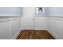 Hallway with hardwood floors, wainscoting, and neutral paint at 345 Rubrum Dr, Hillsborough, NC 27278