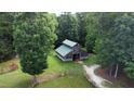 Aerial view of a weathered barn with a green metal roof, nestled amongst lush trees and greenery at 3560 Nc 98, Youngsville, NC 27596