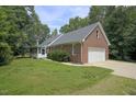 Charming brick home featuring a side entry garage, covered porch, and nicely landscaped yard at 3560 Nc 98, Youngsville, NC 27596