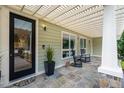 Inviting front porch features stone flooring, a pergola, and cozy rocking chairs at 402 Westwood Dr, Chapel Hill, NC 27516