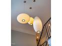 Striking overhead lighting fixtures illuminate a staircase and upper hallway at 402 Westwood Dr, Chapel Hill, NC 27516