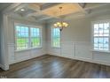 Bright dining room featuring coffered ceilings, wood floors, classic chandelier, and large windows at 511 Valentine Ct, Graham, NC 27253