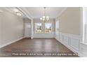 Bright living room with hardwood floors, white wainscoting, and a modern chandelier at 511 Valentine Ct, Graham, NC 27253