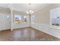 Bright living room with hardwood floors, white wainscoting, and large windows at 511 Valentine Ct, Graham, NC 27253