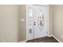 Bright foyer with decorative glass door, sidelight, and dark wood floors at 582 Ebenezer Church Rd, Coats, NC 27521