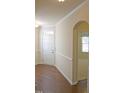 Inviting foyer featuring hardwood floors, a white door, decorative molding, and an arched doorway at 8504 Lasilla Way, Raleigh, NC 27616