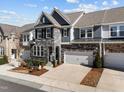 Stylish townhome featuring a stone and siding exterior, with a two-car garage and inviting driveway at 8620 Secreto Dr, Raleigh, NC 27606