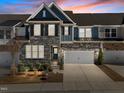 Townhome with stone and siding, illuminated by sunset, showcasing its architectural details and curb appeal at 8620 Secreto Dr, Raleigh, NC 27606