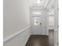 Bright foyer with white walls, dark hardwood floors, and a traditional white front door with glass inserts at 8620 Secreto Dr, Raleigh, NC 27606