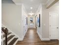 Elegant hallway with hardwood floors, decorative wall trim and a staircase to the upper level at 909 Thimbleweed Way, Wake Forest, NC 27587