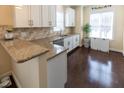 This kitchen features wood floors, white cabinets and granite countertops at 100 Pinto Saddle Ct, Garner, NC 27529
