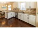 The kitchen has white cabinets, stone backsplash, granite countertops and stainless steel appliances at 100 Pinto Saddle Ct, Garner, NC 27529