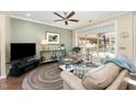 Comfortable living room boasting a large window, hardwood floors, and cozy seating arrangement with a ceiling fan at 1009 Restoration Dr, Durham, NC 27703