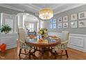 Elegant dining room with hardwood floors, a round table with seating for four, and a decorative chandelier at 10319 Evergreen Spring Pl, Raleigh, NC 27614