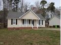 Charming single-story home with neutral siding, black shutters, and a cozy, white picket front porch at 1032 Holly Pointe Dr, Wendell, NC 27591