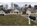 Charming single-story home with neutral siding, black shutters, and a cozy, white picket front porch at 1032 Holly Pointe Dr, Wendell, NC 27591