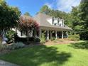 Beautiful home with well-manicured lawn and landscaping, complete with a brick porch and rocking chairs at 106 Woodkirk Ln, Chapel Hill, NC 27514