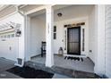 Inviting front porch with classic columns, a black front door, and a cozy seating area with a rocking chair at 1213 Valley Dale Dr, Fuquay Varina, NC 27526