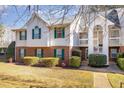 Charming multi-story townhouse with manicured landscaping, brick accents, and private balconies at 1221 Renshaw Ct, Cary, NC 27518