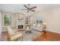 Cozy living room featuring a fireplace, ceiling fan and a comfortable seating arrangement at 1221 Renshaw Ct, Cary, NC 27518