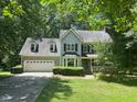 Charming two-story home with light blue siding, complemented by a lush green lawn and mature trees at 1501 Ramson Ct, Raleigh, NC 27603