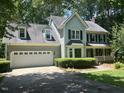 Inviting two-story home features a two-car garage, lush landscaping, and a welcoming front porch at 1501 Ramson Ct, Raleigh, NC 27603